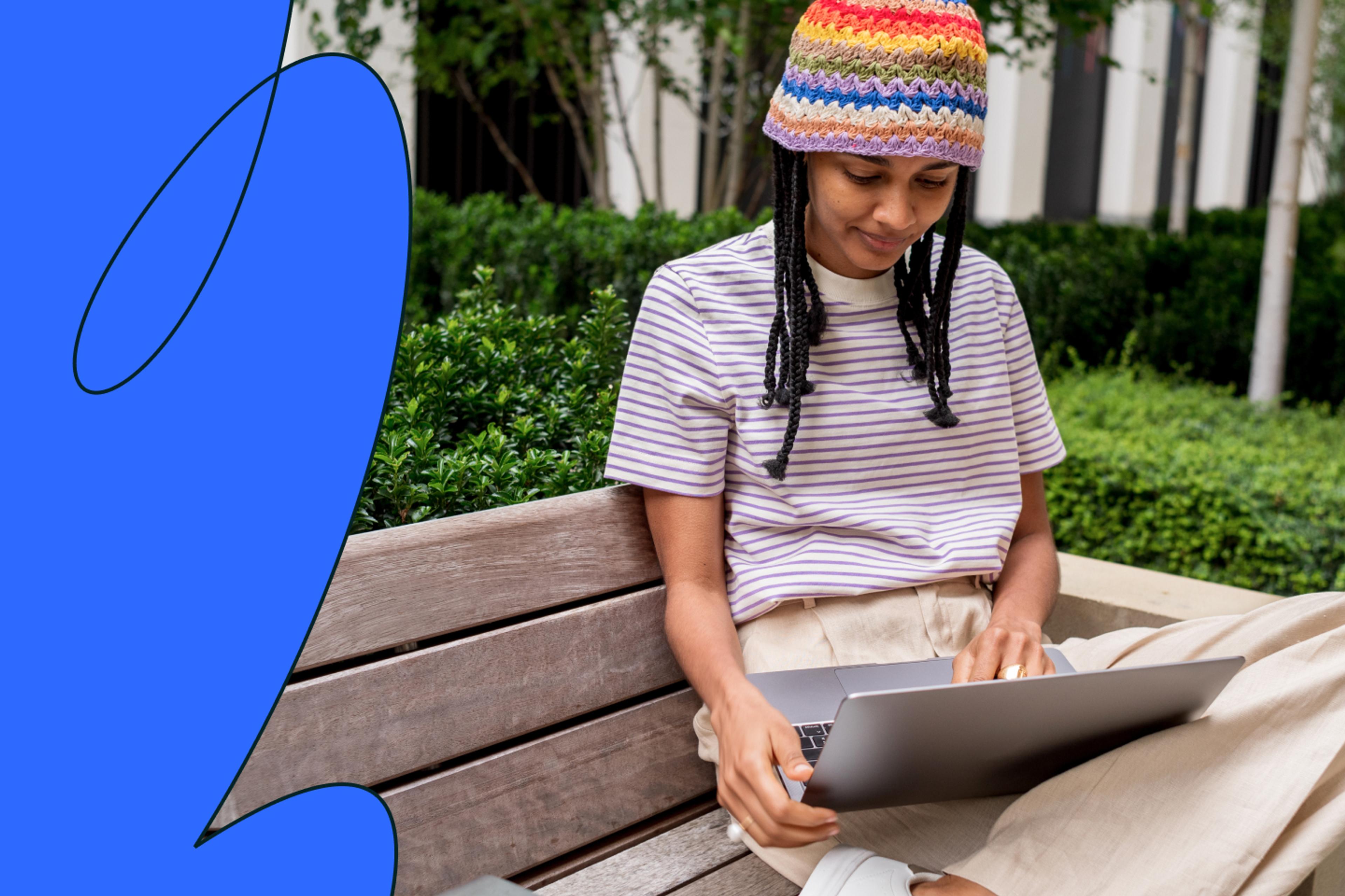 Woman sitting on bench looking at laptop